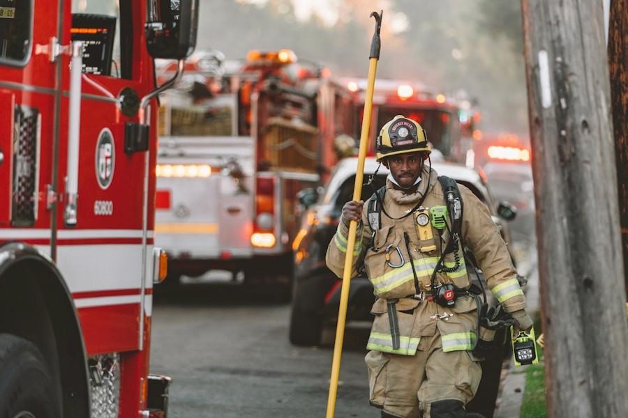 Firefighters in turnout gear beside an engine
