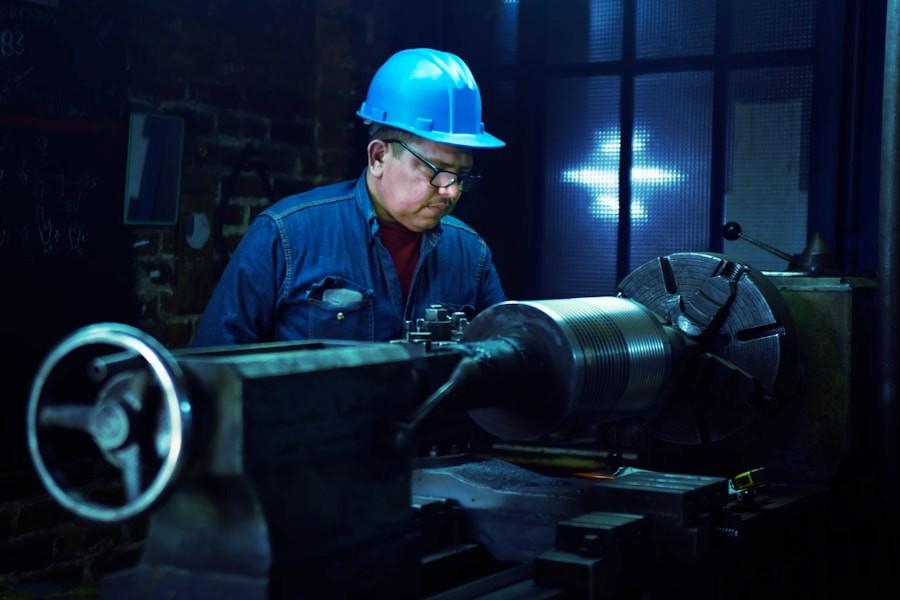 A worker at machinery in an industrial plant